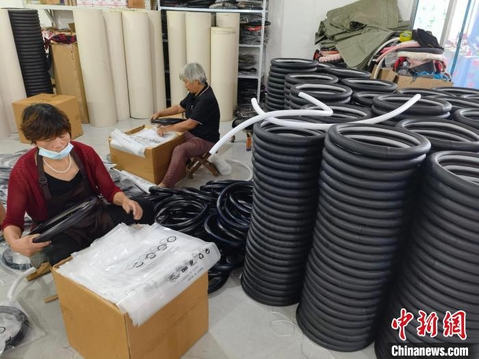 圖為村民在汽車飾品企業(yè)生產(chǎn)車間中工作?！巫雍?攝