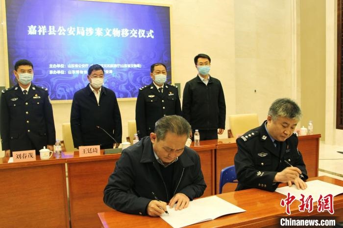山東博物館館長鄭同修和嘉祥縣人民政府副縣長、公安局局長趙健簽署移交協(xié)議。　趙曉 攝