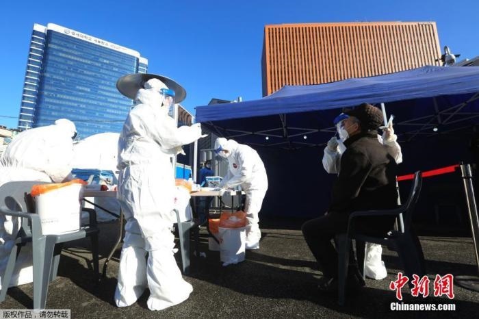 資料圖：韓國首爾，醫(yī)務(wù)人員對市民進行新冠病毒檢測。