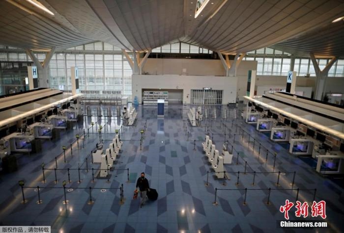 資料圖：日本東京，東京國(guó)際機(jī)場(chǎng)，一名乘客在國(guó)際航班航站樓的登機(jī)區(qū)。