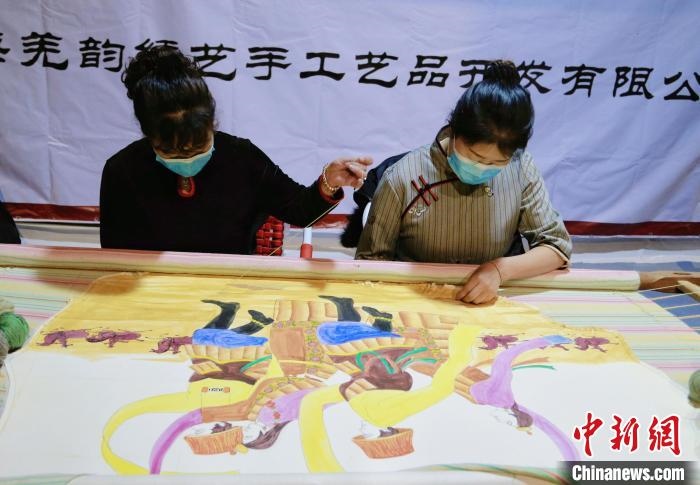 圖為皮繡藝人在市集上“秀”指尖技藝?！●R銘言 攝