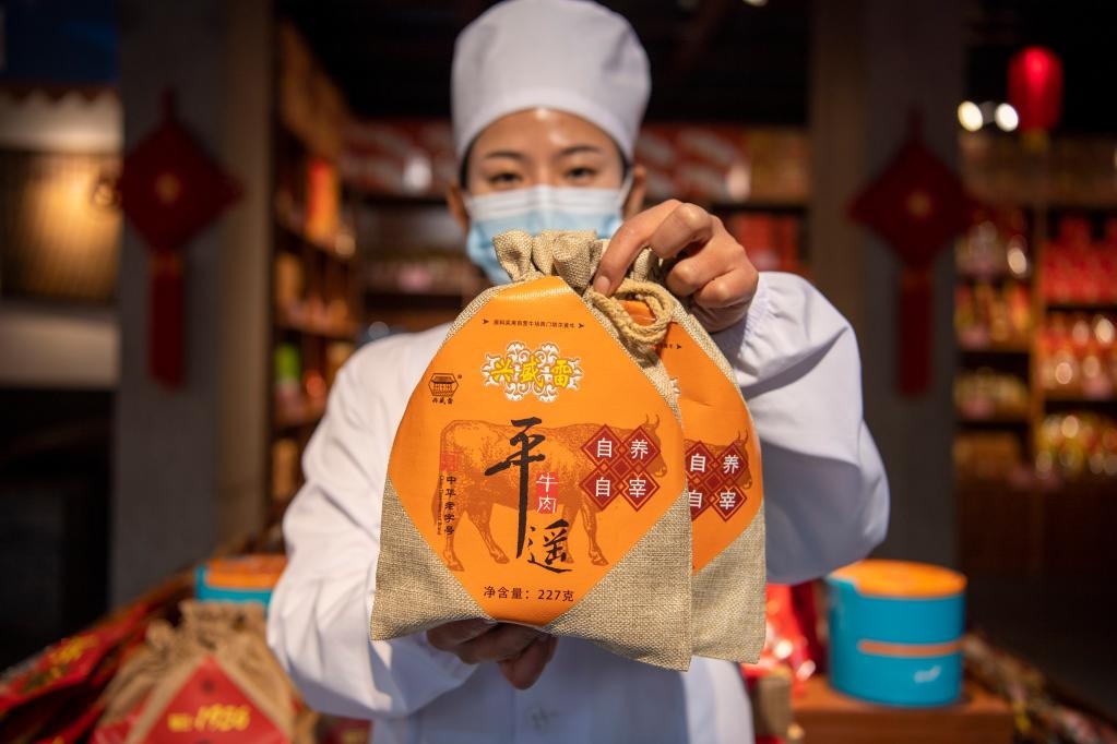 1月27日，在平遙古城南大街的一家平遙牛肉店內(nèi)，工作人員展示一款牛肉產(chǎn)品。新華社記者 楊晨光 攝