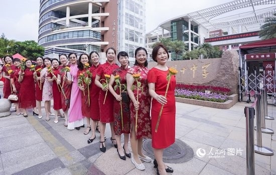 6月7日一早，廈門(mén)雙十中學(xué)考生家長(zhǎng)們身穿旗袍，手拿向日葵在考場(chǎng)外為孩子加油打氣，寓意“旗開(kāi)得勝，一舉奪魁”。人民網(wǎng)記者 陳博攝