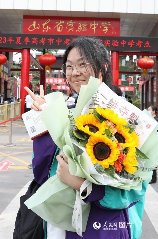 6月7日高考首日，山東67萬(wàn)考生走進(jìn)考場(chǎng)，拼搏逐夢(mèng)。在山東省實(shí)驗(yàn)中學(xué)考點(diǎn)，考生進(jìn)考場(chǎng)前手捧向日葵花拍照留念，寓意“一舉奪魁”。人民網(wǎng)記者 劉祺攝