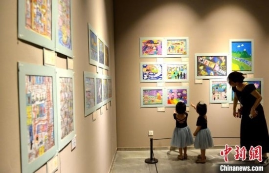 圖為家長帶著孩子參觀展覽。呂明 攝