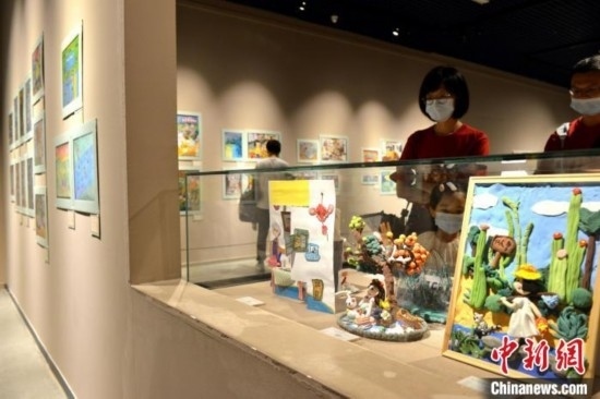 圖為家長帶著孩子參觀展覽。呂明 攝