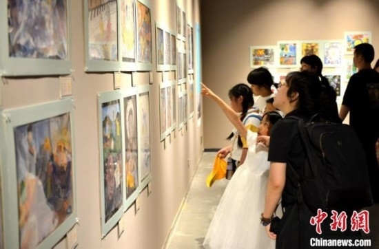 圖為家長帶著孩子參觀展覽。呂明 攝