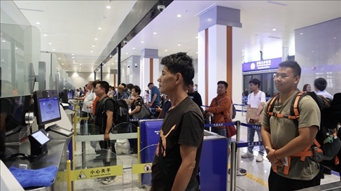 6月13日，乘坐中老鐵路國(guó)際旅客列車的旅客在磨憨邊檢大廳排隊(duì)候檢。李揚(yáng) 攝