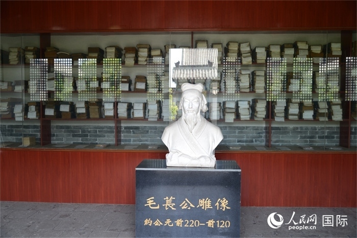 河間詩(shī)經(jīng)齋毛萇雕像。雕像后書櫥中陳列的是歷代各版本《詩(shī)經(jīng)》及譯本。 人民網(wǎng) 趙昭攝