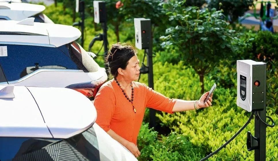 2023年5月24日，山東省膠州市新立街小區(qū)內(nèi)一位居民使用電動汽車充電樁掃碼充電。該小區(qū)加裝各類智慧設(shè)備，打造“智慧社區(qū)”，為居民生活帶來便利。