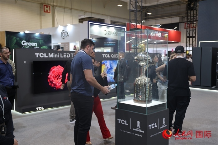參觀者在TCL展臺前觀看南美解放者杯獎杯，據(jù)介紹，TCL是南美解放者杯（2023—2026賽季）全球官方合作伙伴。（人民網(wǎng)記者 時元皓攝）