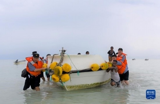 7月21日，中國海軍“和平方舟”號醫(yī)院船醫(yī)護(hù)人員涉水登島，前往基里巴斯一診療點(diǎn)。新華社記者 黎云 攝