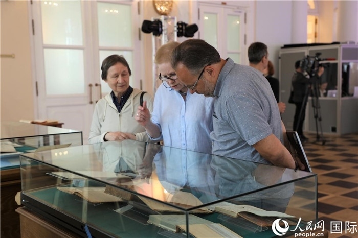 中俄圖書館論壇嘉賓共同參觀由俄羅斯國立列寧圖書館舉辦的館藏中國古籍善本圖書展。人民網(wǎng)記者 隋鑫攝