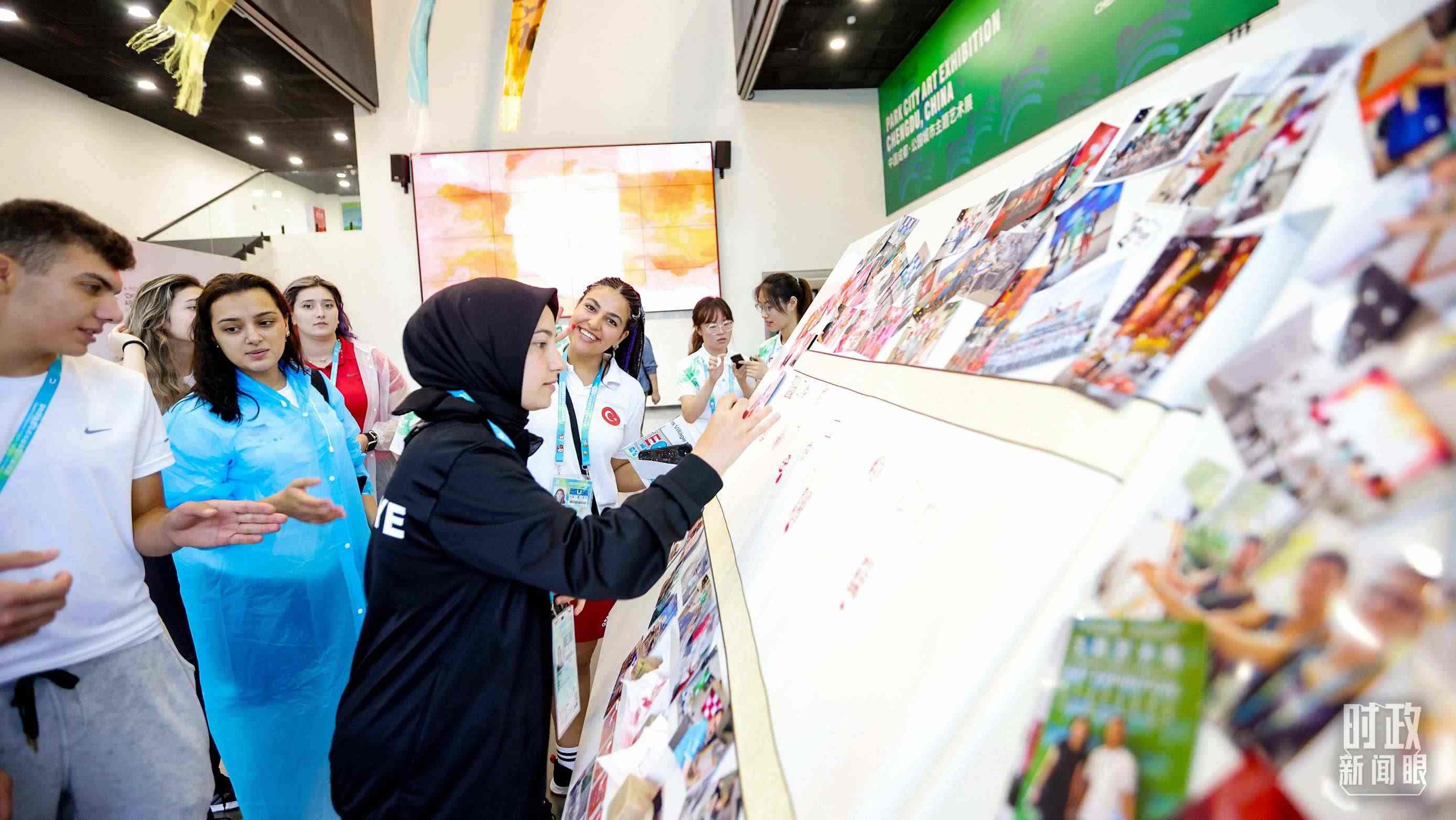 各國青年運動員正在參觀成都大運村內的“雪山下的公園城市，煙火里的幸福成都”主題藝術展。（總臺央視記者魏幫軍拍攝）