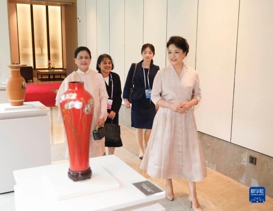 7月27日下午，國家主席習(xí)近平夫人彭麗媛在四川成都會見陪同印度尼西亞總統(tǒng)佐科來華出席第31屆世界大學(xué)生夏季運動會開幕式并訪華的總統(tǒng)夫人伊莉亞娜。這是彭麗媛和伊莉亞娜欣賞成都特色非遺工藝品。新華社記者 丁林 攝