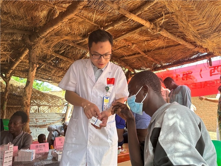 圖為南昌大學(xué)第一附屬醫(yī)院病理科主治醫(yī)師張振東為村民解說藥品使用方法。中國駐乍得醫(yī)療隊供圖