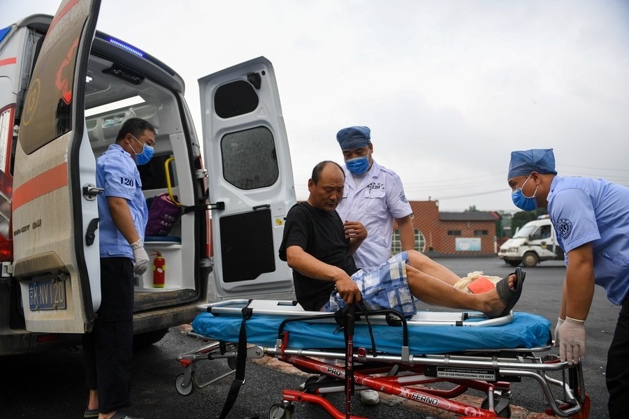8月1日，在北京市門頭溝區(qū)妙峰山鎮(zhèn)妙峰山民族學(xué)校臨時(shí)安置點(diǎn)，北京急救中心工作人員在轉(zhuǎn)運(yùn)一名受傷村民。新華社記者 鞠煥宗 攝