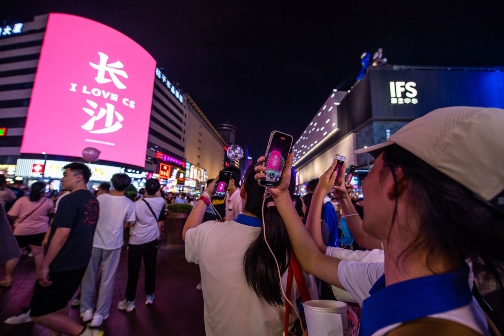  游客在長(zhǎng)沙市天心區(qū)黃興路步行街打卡、拍照（6月7日攝）。新華社記者 陳思汗 攝