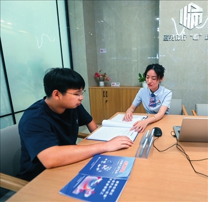 在杭州市臨安區(qū)政務(wù)服務(wù)中心的“為企服務(wù)中心”，黨員志愿者（右）解答企業(yè)主的疑問（2023年7月7日攝）。徐昱攝/本刊