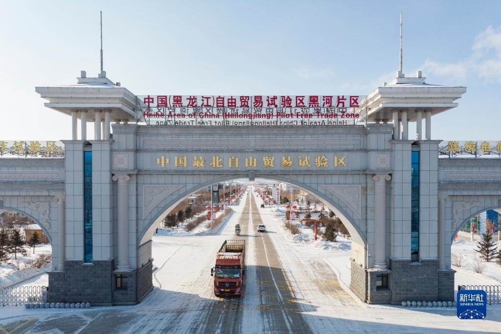 2月11日，車輛駛出中國(guó)（黑龍江）自由貿(mào)易試驗(yàn)區(qū)黑河片區(qū)大門（無人機(jī)照片）。新華社記者 謝劍飛 攝