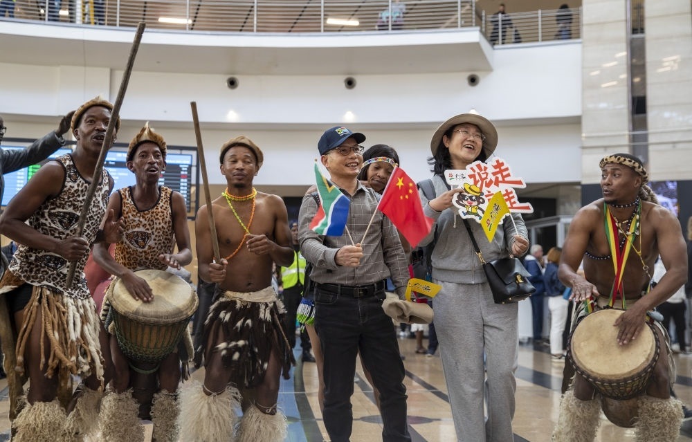 在南非約翰內(nèi)斯堡坦博國際機場，南非舞蹈演員歡迎中國試點恢復(fù)出境團隊旅游后首批抵達南非的中國游客（2023年3月29日攝）。