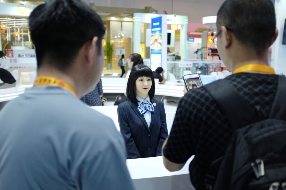 9月1日，媒體記者在國(guó)家會(huì)議中心與服務(wù)機(jī)器人互動(dòng)。新華社記者 劉夢(mèng)琪 攝