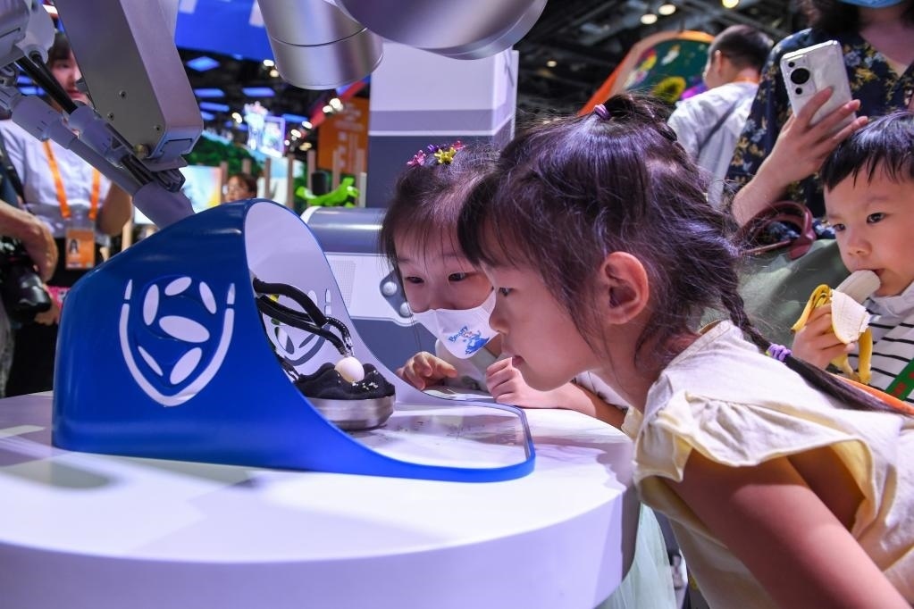 9月3日，幾名小朋友在國(guó)家會(huì)議中心觀看單孔腔鏡手術(shù)機(jī)器人展示。新華社記者 鞠煥宗 攝