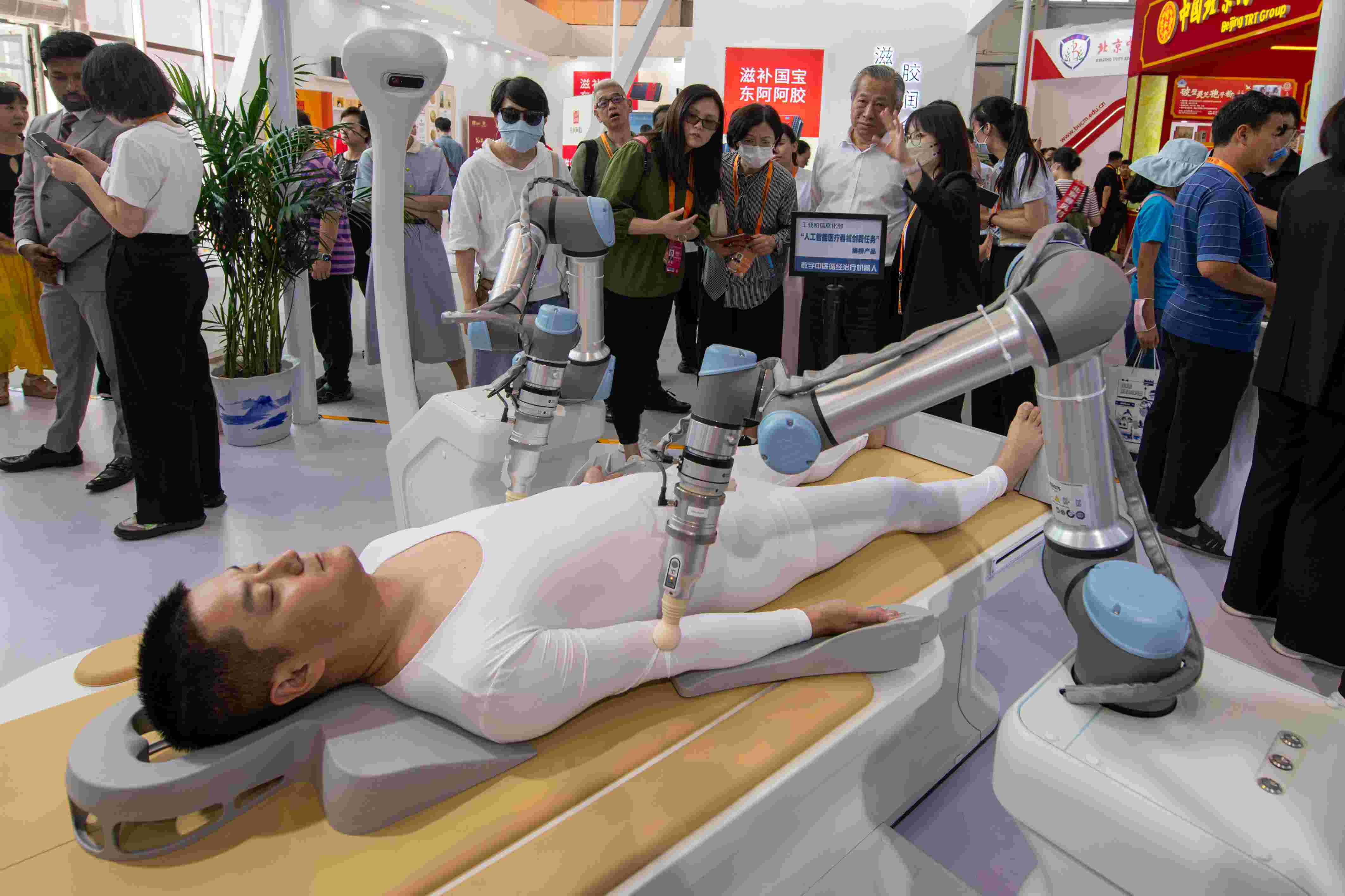 在位于首鋼園的健康衛(wèi)生服務(wù)展區(qū)，觀眾正在參觀數(shù)字中醫(yī)循經(jīng)治療機(jī)器人。人民網(wǎng)記者 翁奇羽攝