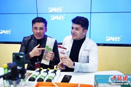 2023年3月，甘肅省慶陽市環(huán)縣電商創(chuàng)業(yè)孵化基地內(nèi)，來自蘭州文理學(xué)院的塔吉克斯坦留學(xué)生正在協(xié)助主播直播帶貨當(dāng)?shù)剞r(nóng)特產(chǎn)品。李亞龍 攝