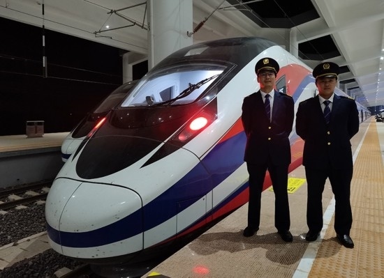 劉銀能（右一）與中國師父鄔俊鴻在動(dòng)車組前合影。受訪者供圖