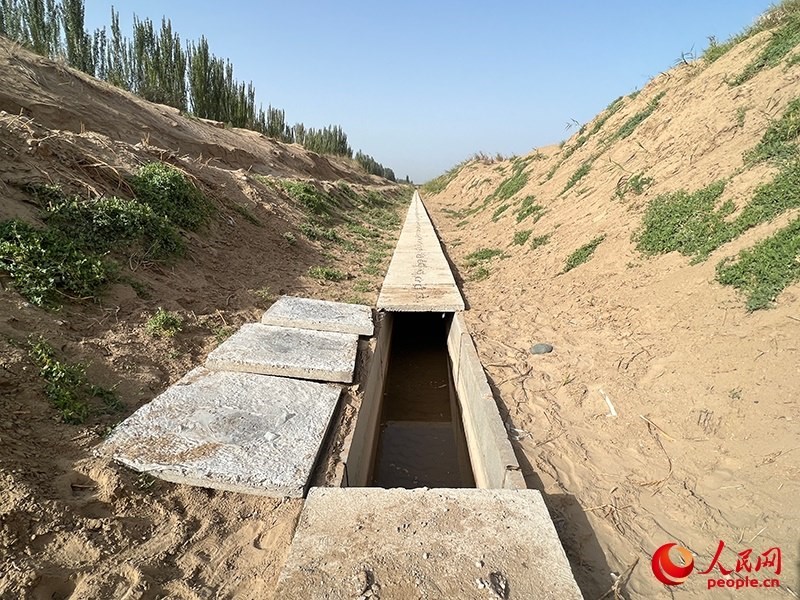 打開(kāi)蓋板，可見(jiàn)水在寬一米、深一米的渠道內(nèi)暢通流過(guò)。人民網(wǎng)記者 常雪梅攝