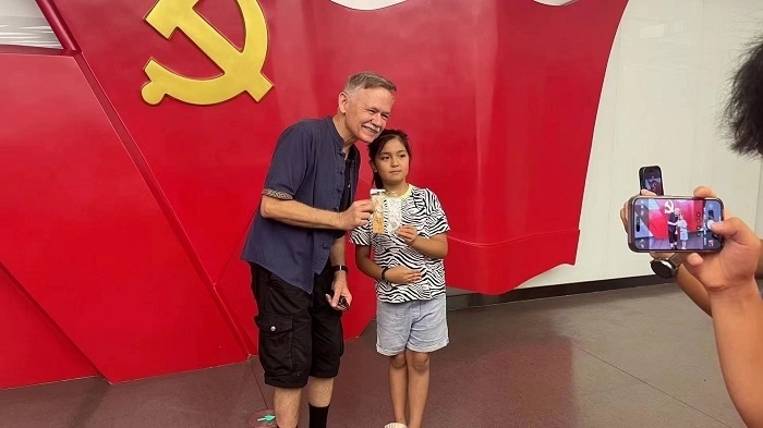 潘維廉和志愿講解員紀(jì)念合影。主辦方供圖