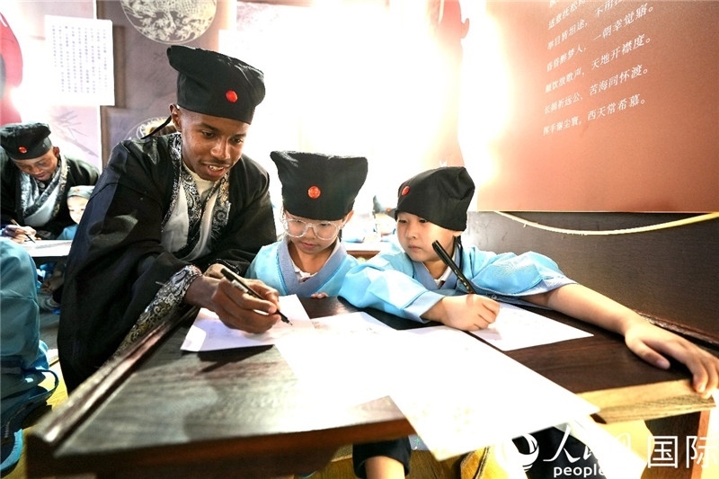 圖為選手與同學(xué)們一起寫書法。人民網(wǎng) 盧鵬宇攝