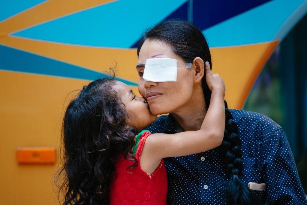 2019年3月15日，在柬埔寨磅湛省醫(yī)院，即將接受白內(nèi)障手術(shù)的患者孫美樂(lè)接受女兒的親吻祝福。在接受了中國(guó)醫(yī)療隊(duì)的白內(nèi)障義診手術(shù)后，她的視力逐步恢復(fù)，生活有了新的光明和希望。