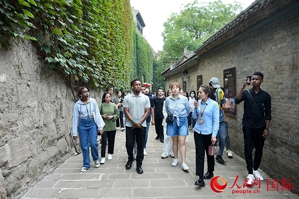 選手們認(rèn)真聆聽導(dǎo)游講解。人民網(wǎng) 盧鵬宇攝