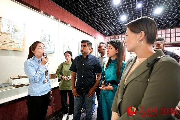 選手們認(rèn)真聆聽導(dǎo)游講解。人民網(wǎng) 盧鵬宇攝