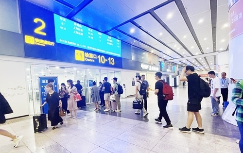 在快速進(jìn)站廳前排隊等待檢票的旅客。人民網(wǎng)記者 喬雪峰攝