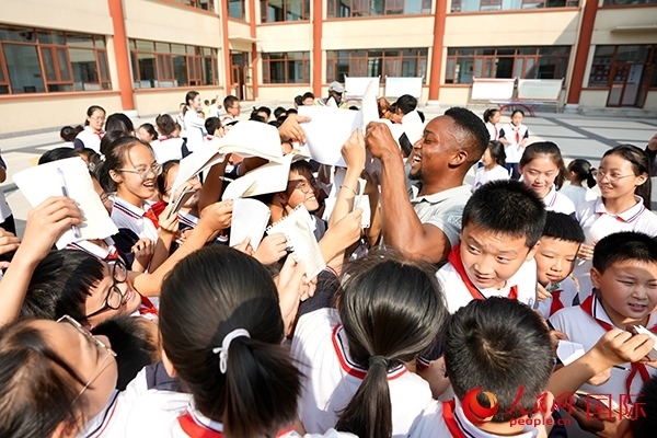 孩子們和選手互動(dòng)簽名。人民網(wǎng) 盧鵬宇攝