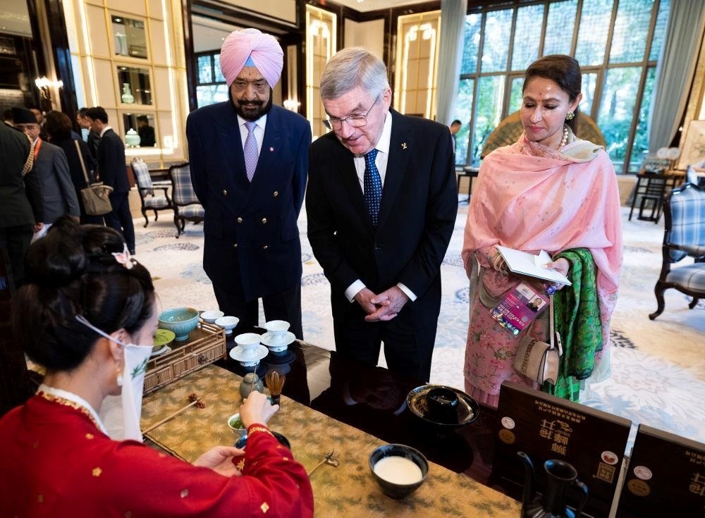 △歡迎宴會前，亞奧理事會代理主席辛格和夫人維尼塔、國際奧委會主席巴赫欣賞非遺展示。