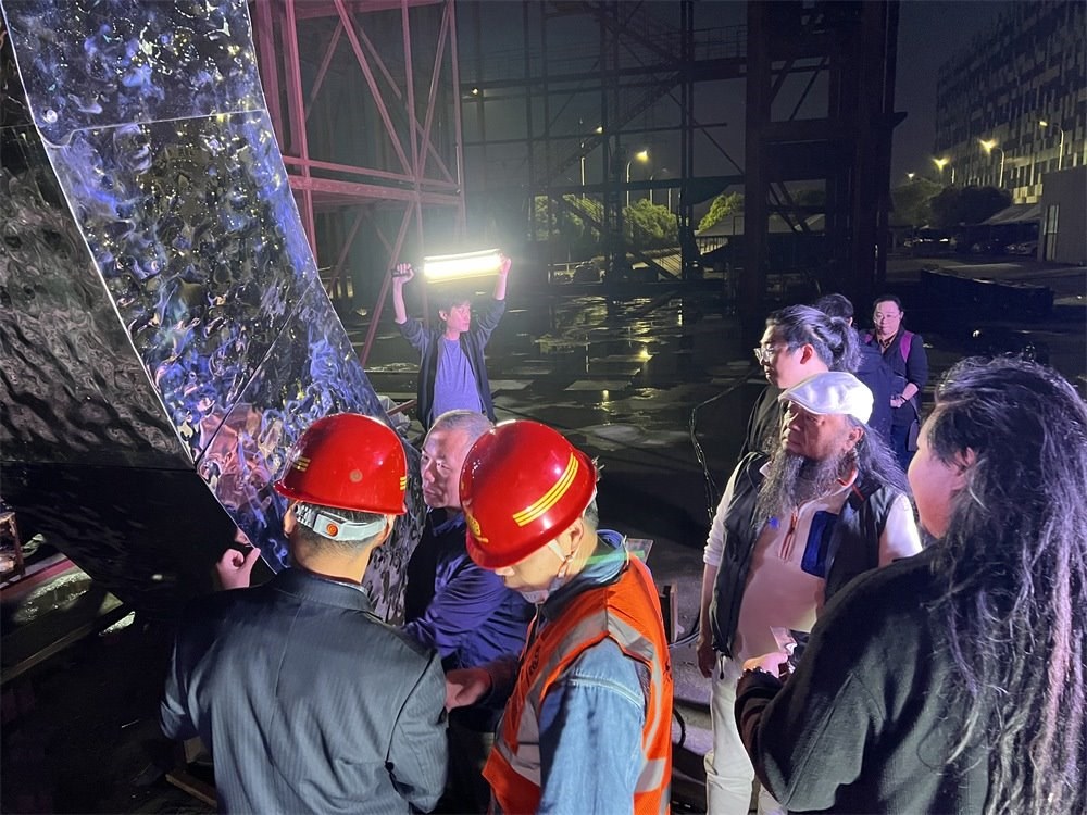 林崗（右二）和團(tuán)隊(duì)查看主火炬制作進(jìn)度。受訪者供圖