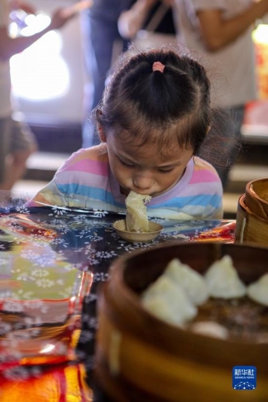 9月27日，小朋友在南翔小籠長街宴上品嘗南翔小籠。