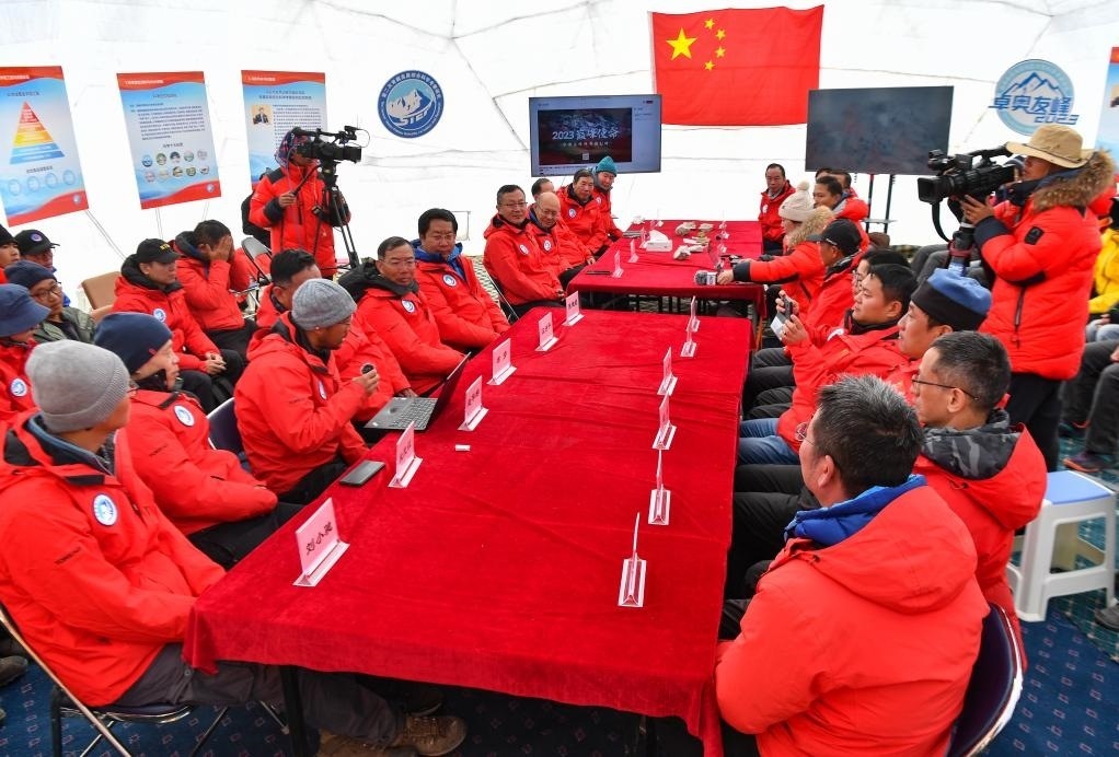 海拔4950米的卓奧友峰科考大本營，科考隊員趙華標（手拿麥克風看電腦者）在宣讀剛剛接收到的頂峰氣象觀測數(shù)據(jù)，這標志著峰頂自動氣象站架設(shè)成功，成功傳回觀測數(shù)據(jù)（10月1日攝）。新華社記者晉美多吉 攝
