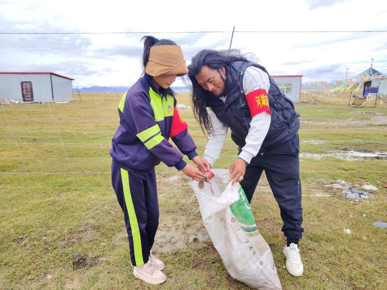 玉樹州稱多縣珍秦鎮(zhèn)河湖志愿者才培和他女兒更求拉毛在清掃垃圾。受訪者供圖