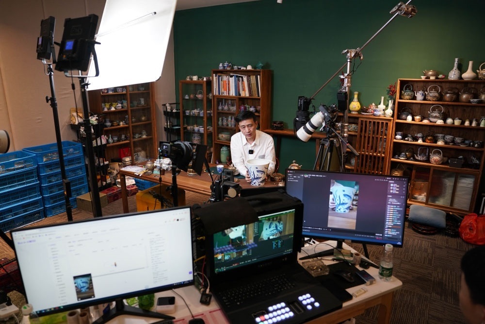 ↑在景德鎮(zhèn)，工作人員通過網(wǎng)絡直播推介陶瓷產(chǎn)品（2023年2月22日攝）。