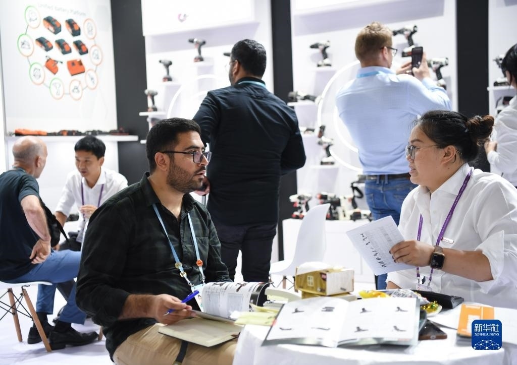 10月15日，在一家電動(dòng)工具展臺(tái)，外國采購商在洽談業(yè)務(wù)。新華社記者 鄧華 攝