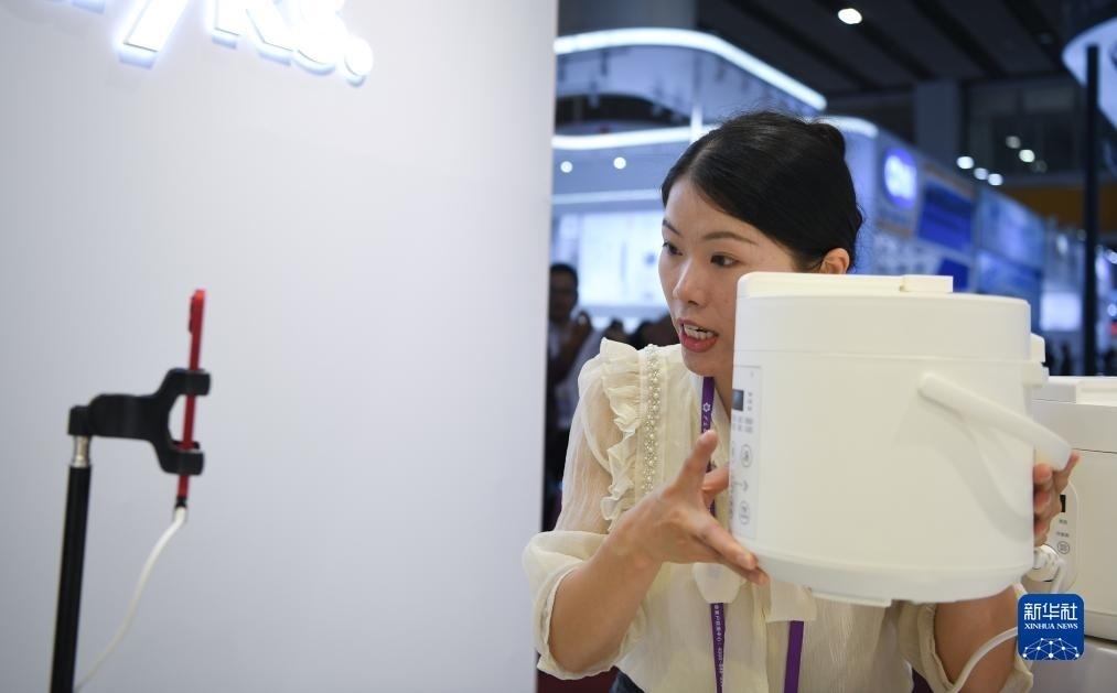 10月15日，參展的工作人員在展臺(tái)直播介紹家電產(chǎn)品。新華社記者 鄧華 攝