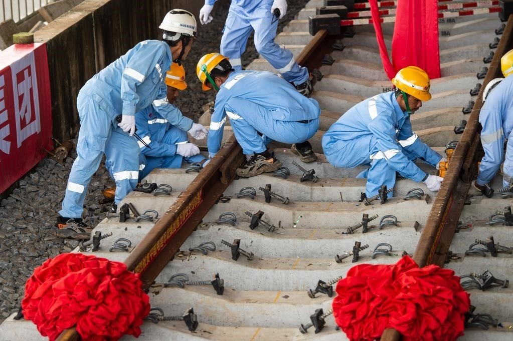 3月31日，在印度尼西亞雅加達(dá)雅萬高鐵哈利姆車站，工人鋪設(shè)雅萬高鐵全線最后一根鋼軌。