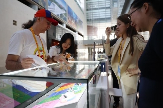 10月16日，參會(huì)記者在“一帶一路”國(guó)際合作高峰論壇新聞中心參觀展示的中國(guó)非物質(zhì)文化遺產(chǎn)展品。新華社記者 陳斌 攝