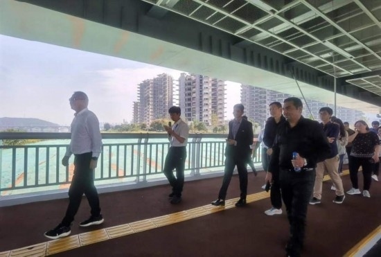 10月24日，2023“一帶一路”媒體合作論壇聯(lián)合采訪團(tuán)團(tuán)員走在清水塘大橋景觀通道上。本報(bào)記者 常雯宜攝