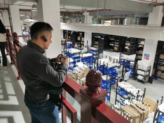 2023“一帶一路”媒體合作論壇聯(lián)合采訪團(tuán)團(tuán)員在仁和醫(yī)藥物流園拍攝記錄轉(zhuǎn)運(yùn)流程。（本報(bào)記者 黃超攝）